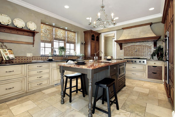 Luxury kitchen cabinets with stained and painted pieces. Faux finished range hood with wood accents and corbels.
