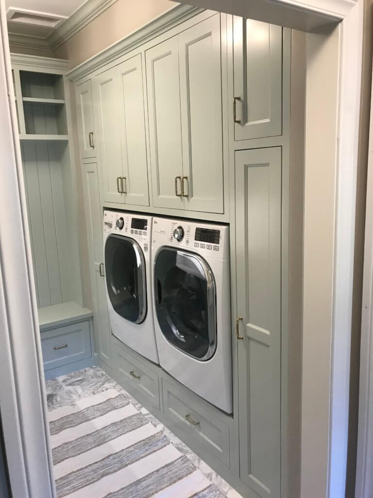 Light green custom laundry cabinets in the shaker style.